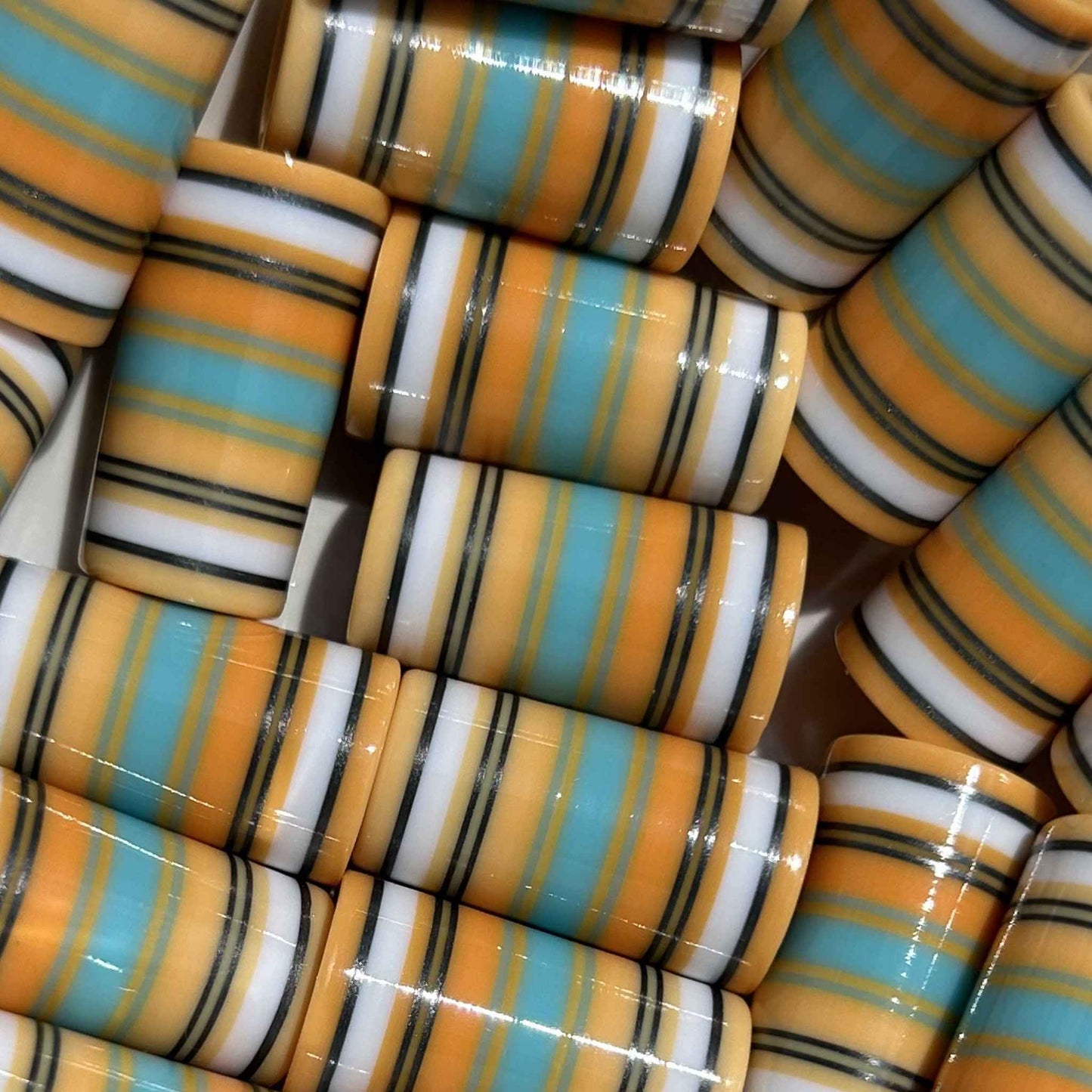 Orange cream golf ferrules with teal, white, and black accent stripes.