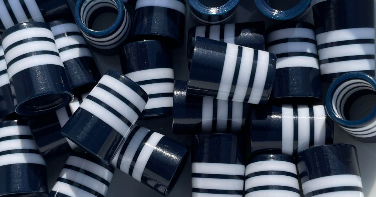 pile of 3d-printed navy blue golf ferrules with white stripes