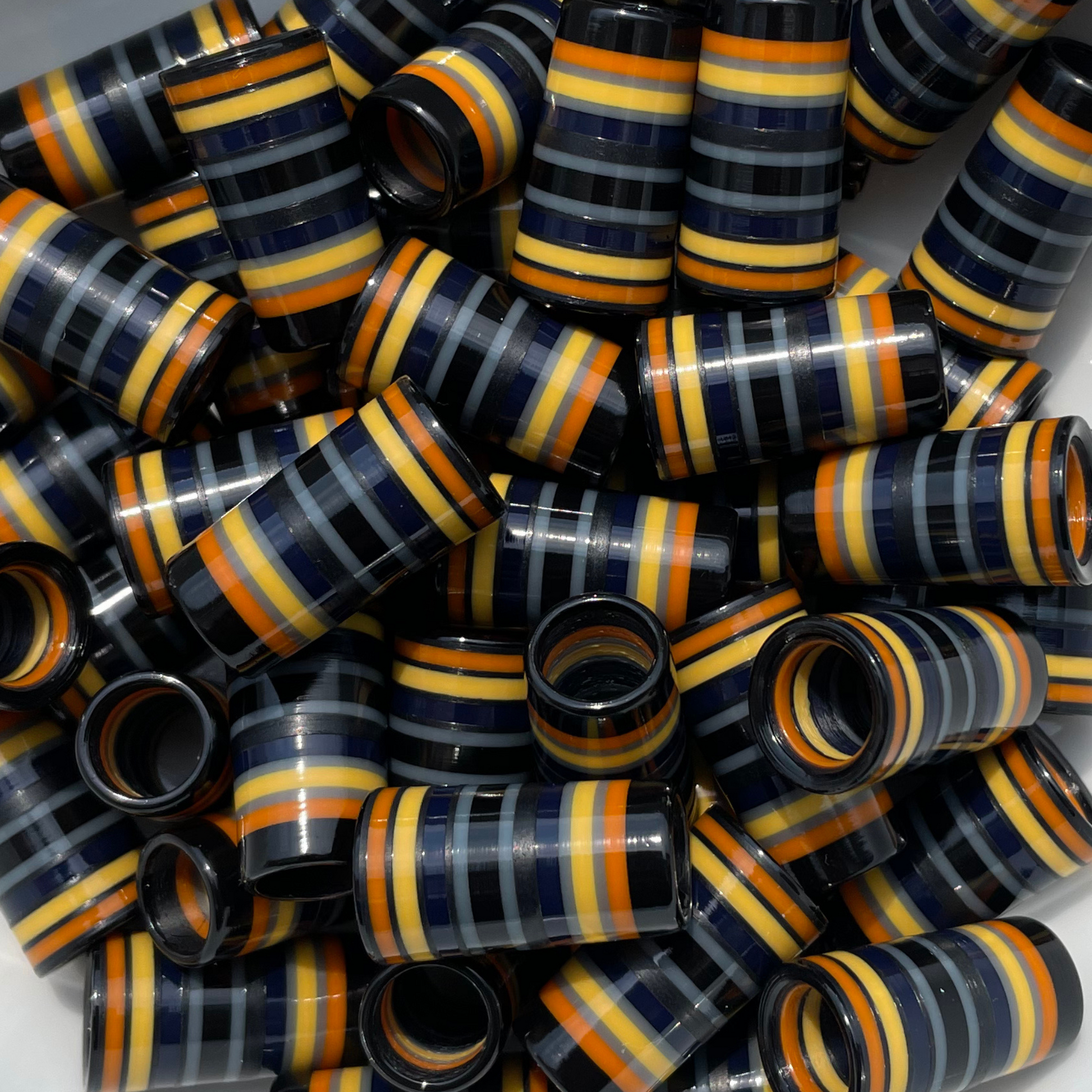 pile of earth-toned golf ferrules in black, orange, yellow, navy, and gray