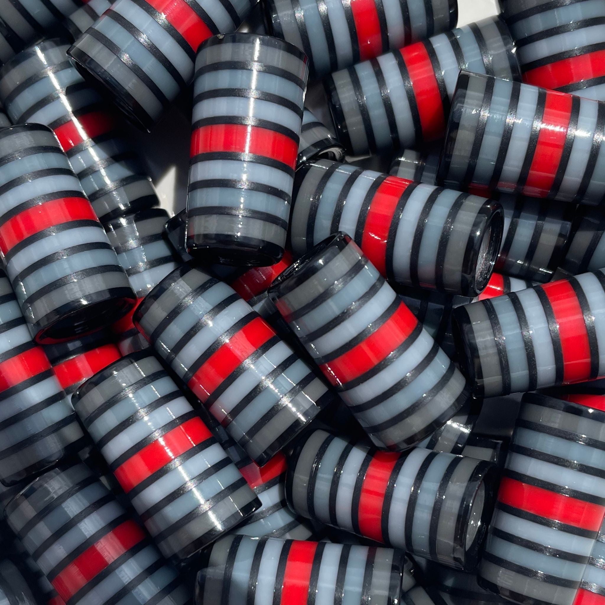 Stack of golf ferrules in shades of gray with a red center stripe