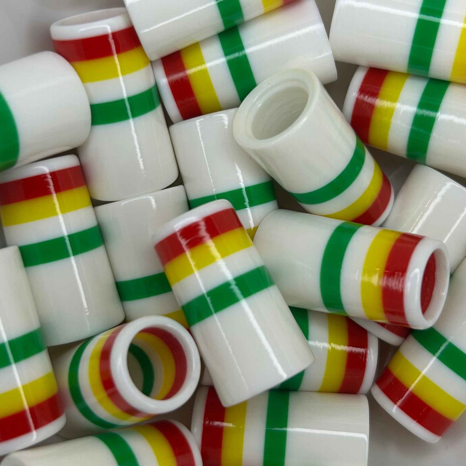 pile of 1" white golf ferrules with green, white, yellow, and red stripes at the top