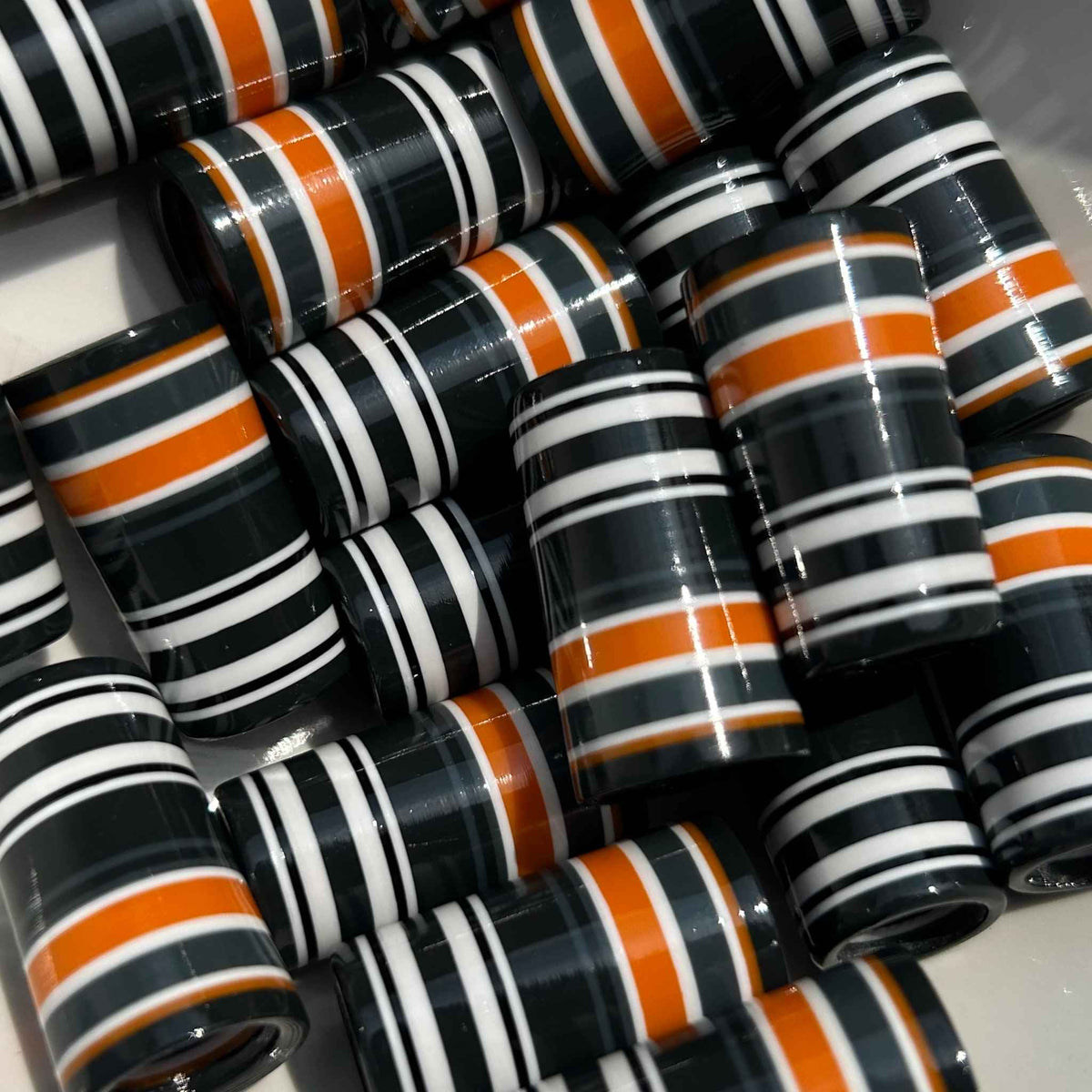 Black, orange, gray, and white 3D-printed golf ferrules.