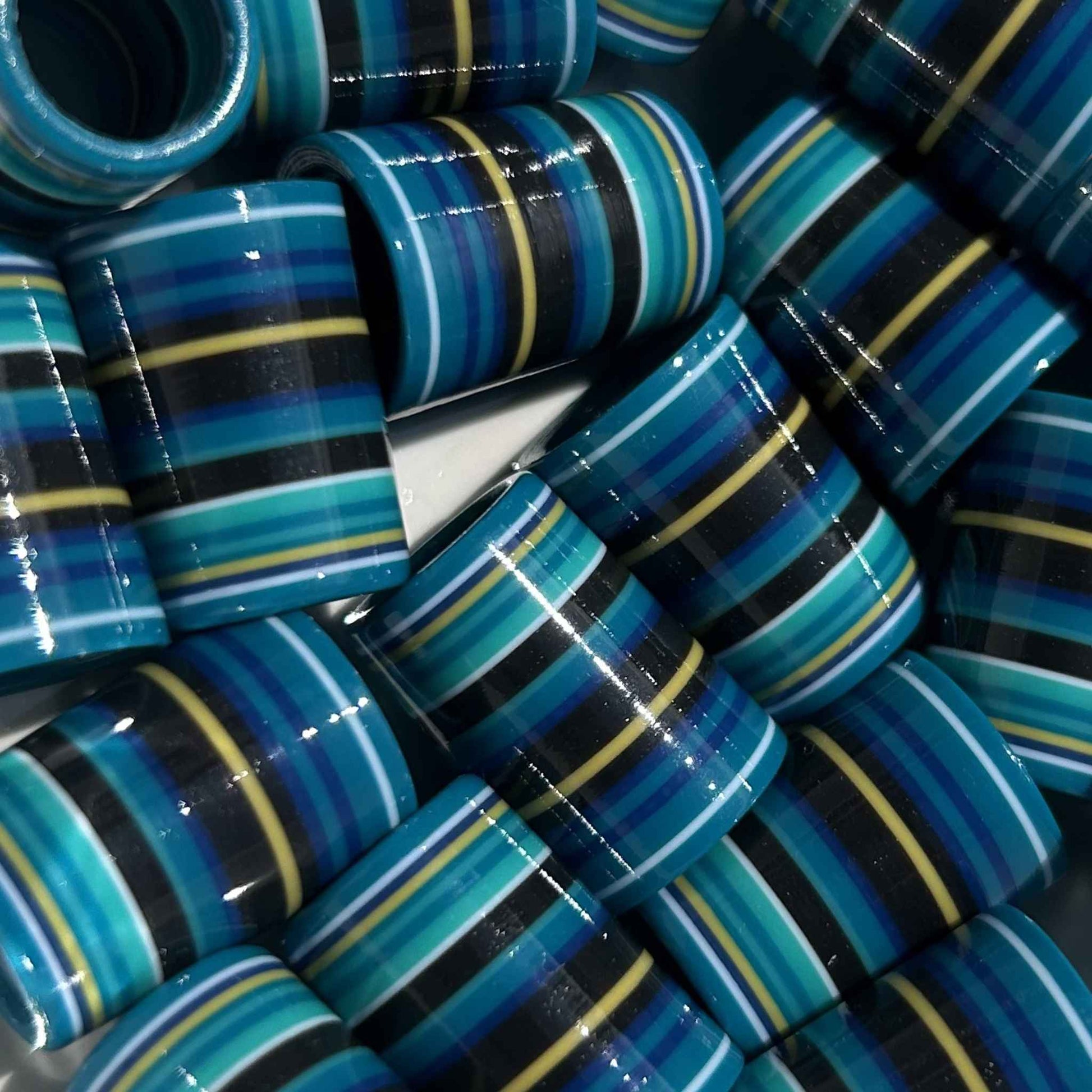 3d-printed golf ferrules in shades of blue & teal with yellow, black and white accents