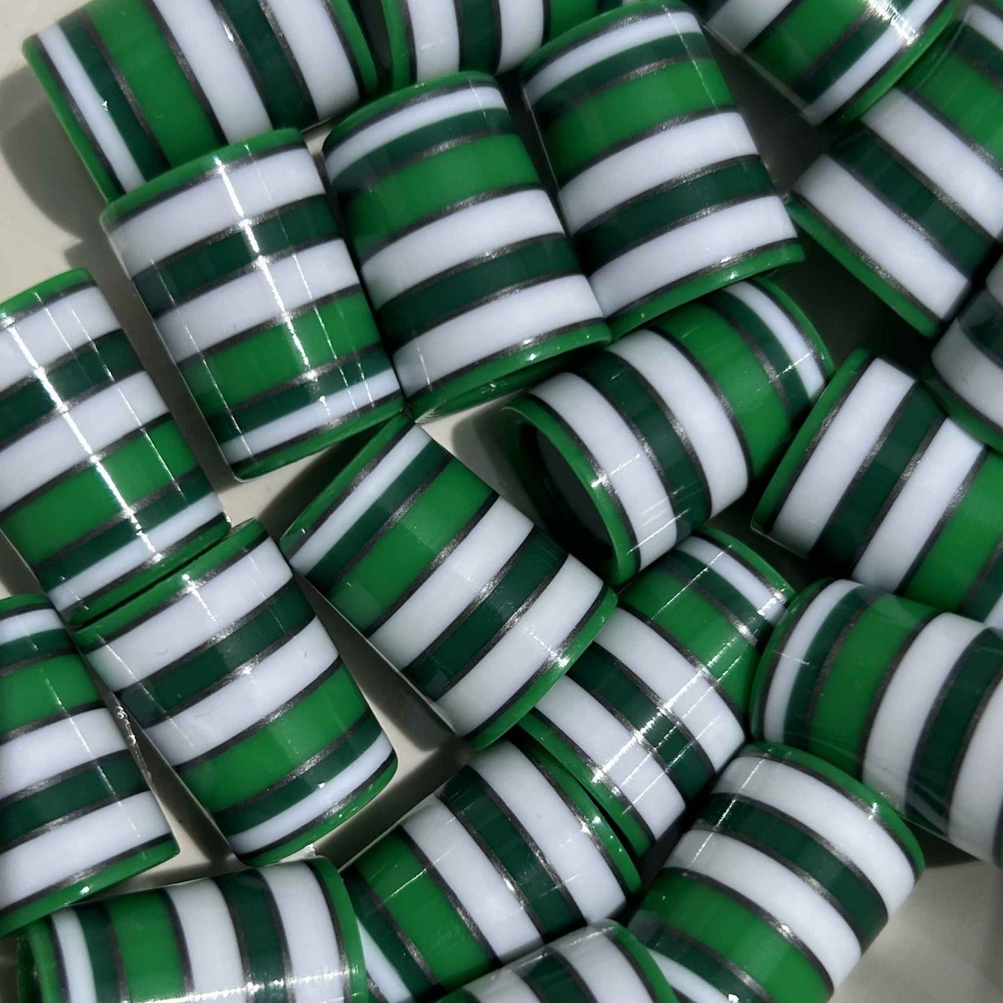 pile of three-quarter inch green, silver, and white golf ferrules